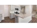 Bright kitchen boasts stainless appliances, white cabinets, and a large center island at 236 Moore Creek Dr, Fuquay Varina, NC 27526