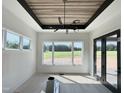Sunlit dining room featuring large windows with backyard view, wood paneled ceiling, and modern lighting fixture at 280 Forest Bridge Rd, Franklinton, NC 27525