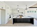 Well-lit kitchen with a large island, stylish pendant lighting, and sleek white cabinets, and stainless steel appliances at 280 Forest Bridge Rd, Franklinton, NC 27525