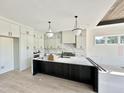 Bright kitchen featuring white cabinets, a marble backsplash, a large island, and modern pendant lighting at 280 Forest Bridge Rd, Franklinton, NC 27525