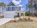 Beautiful two-story home featuring blue siding, landscaped lawn, and a two-car garage at 121 Plainfield Ln # 134, Lillington, NC 27546
