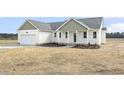 Charming single-story home with a two-car garage, green trim, and freshly laid mulch at 233 Surles Rd, Benson, NC 27504
