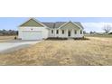 Charming single-story home with a two-car garage, green trim, and freshly laid mulch at 233 Surles Rd, Benson, NC 27504