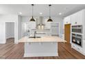 Modern kitchen featuring a central island with seating, stainless steel appliances and wood flooring at 33 Macy Cir, Wendell, NC 27591