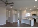 Open concept kitchen with white cabinets, stainless steel appliances, and a large center island at 73 High Hampton Way, Fuquay Varina, NC 27526