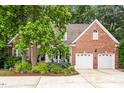 Brick home with two-car garage and lush landscaping at 8764 Wildwood Links, Raleigh, NC 27613