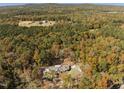 Aerial view of the home nestled in the forest surrounded by fall foliage at 1414 Whippoorwill Ln, Chapel Hill, NC 27517
