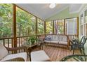 Relaxing screened porch with wooden floors, wicker furniture, ceiling fan, and wooded views at 413 Chadwick Ln, Efland, NC 27243
