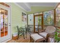 Cozy screened porch features seating area, wooden floors, and view of the backyard at 413 Chadwick Ln, Efland, NC 27243