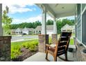 Relaxing front porch view with a rocking chair overlooking the neighborhood's landscaped streets and well-maintained homes at 1401 Black Locust Ln, Fuquay Varina, NC 27526