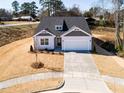 Well-manicured front yard of single story home leading to the welcoming two-car garage at 326 Little Creek Dr, Lillington, NC 27546