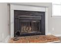 Brick fireplace with black metal screen and andirons at 501 Kendall Dr, Durham, NC 27703