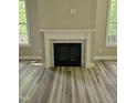 Living room fireplace with decorative mantel, marble surround, and wood-look floors at 698 Magnolia Acres Ln, Fuquay Varina, NC 27526