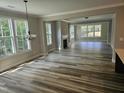 Spacious living room with wood-look floors, fireplace, and abundant natural light at 698 Magnolia Acres Ln, Fuquay Varina, NC 27526