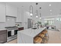Open-concept kitchen with a large island, pendant lighting, and stainless steel appliances at 10 Seawell Ave # 105, Raleigh, NC 27601