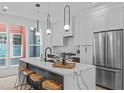 Bright kitchen featuring white cabinets, a marble waterfall island, and stainless steel appliances at 10 Seawell Ave # 105, Raleigh, NC 27601