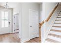 Bright foyer with hardwood floors, white walls, wood stairs, and white trim at 240 Fast Pitch Ln, Four Oaks, NC 27524