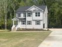 Well-maintained two-story home with gray siding, a welcoming front porch, and a newly installed driveway at 266 Fast Pitch Ln, Four Oaks, NC 27524