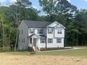 Two-story home with gray siding and black shutters featuring a well-manicured lawn and tidy landscaping at 266 Fast Pitch Ln, Four Oaks, NC 27524