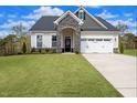 Charming home with a stone entryway, well-manicured lawn, and two-car garage at 52 Macy Cir, Wendell, NC 27591