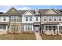 Charming townhome featuring stone accents, a welcoming entrance, and manicured landscaping at 951 Alma Railway Dr # 561, Wake Forest, NC 27587