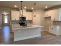 Bright kitchen features an island with quartz countertops, white cabinetry, and stainless steel appliances at 96 Little Creek Dr, Lillington, NC 27546