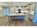 Modern kitchen featuring an island, stainless appliances, pendant lighting, and hardwood floors at 1044 Fairhaven Dr # 100, Mebane, NC 27302