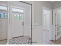 Bright foyer featuring decorative tile flooring, white wainscoting, and an exterior door at 34 Macy Cir, Wendell, NC 27591