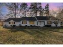 Charming single-story home with a well-manicured front lawn and mature trees at dusk at 234 Crumpler Rd, Kenly, NC 27542