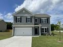 Charming two-story home with gray siding, white trim, black shutters and a two car garage at 158 Citizens Ct # 32, Four Oaks, NC 27524