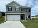 Attractive two-story home with gray siding, black shutters, and a spacious two-car garage on a green lawn at 158 Citizens Ct # 32, Four Oaks, NC 27524