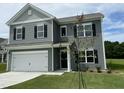 Inviting two-story home with gray siding, black shutters, and a well-manicured lawn with a newly planted tree at 158 Citizens Ct # 32, Four Oaks, NC 27524