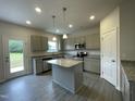 Well-lit kitchen featuring gray cabinets, granite countertops, stainless steel appliances, and an island at 158 Citizens Ct # 32, Four Oaks, NC 27524
