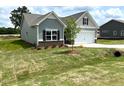 Charming craftsman-style home with vinyl siding, a two-car garage, and manicured front lawn at 346 Olivia Crossing Ct # 12, Four Oaks, NC 27524