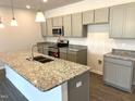Modern kitchen with stainless steel appliances, granite countertops, and an island with sink at 346 Olivia Crossing Ct # 12, Four Oaks, NC 27524
