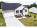 Beautiful home exterior featuring a stone-accented porch, manicured lawn, and attached two-car garage at 490 Barbour Farm Ln, Four Oaks, NC 27524