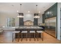Spacious eat-in kitchen with a large center island, modern lighting, and stainless steel appliances at 736 Golfers View Vw, Pittsboro, NC 27312