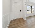 Bright foyer with wood flooring, white trim, and a view of the front porch at 1228 Cricket St, Elon, NC 27244