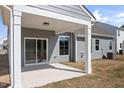 Covered back porch with concrete flooring and white support beams, perfect for outdoor relaxation at 1232 Cricket St, Elon, NC 27244