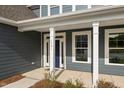 Close-up of the home's entry with a blue door, address numbers, and white columns at 1301 Cricket St, Elon, NC 27244