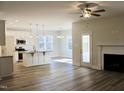 Spacious living room with wood floors, fireplace, ceiling fan, and eat-in kitchen at 59 Mossy Bridge Ct, Lillington, NC 27546