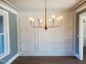 Stylish dining room with paneled accent wall, modern chandelier, and natural light at 70 Water Willow Ln, Zebulon, NC 27597