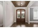 Elegant entryway featuring a wood-paneled ceiling, chandelier, and glass-paneled double doors at 70 Water Willow Ln, Zebulon, NC 27597