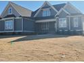Attractive gray two-story home with a well manicured lawn under a clear, blue sky at 70 Water Willow Ln, Zebulon, NC 27597