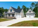 Beautiful home exterior showing attached two-car garage and detached three-car garage at 160 Purslane Dr, Franklinton, NC 27525