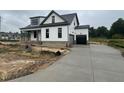 New construction home with a concrete driveway leading to an attached garage and covered porch at 5124 Grist Stone Way, Youngsville, NC 27596