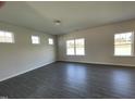Bright living room with wood-look flooring and large windows, offering plenty of natural light at 180 Deodora Ln, Cameron, NC 28326