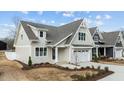 Charming two-story home featuring a classic white garage, complemented by lush landscaping at 418 S Cross St, Youngsville, NC 27596