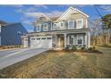 Charming two-story home boasts a stone facade, attached garage, and well-maintained lawn at 611 Highview Dr, Benson, NC 27504
