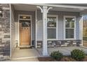 Inviting front entrance with a wooden door, stone accents, and manicured landscaping at 611 Highview Dr, Benson, NC 27504
